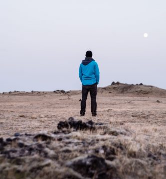 una persona parada en un campo seco